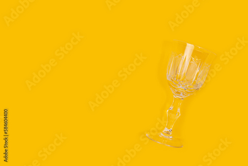 Vintage crystal glass on a yellow background. Minimal composition with copy space.