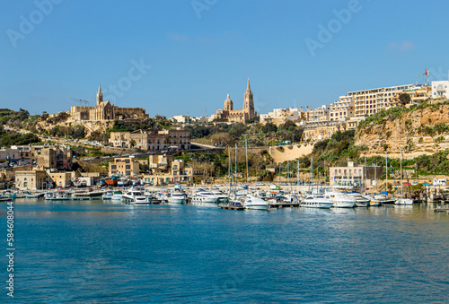 Fototapeta Naklejka Na Ścianę i Meble -  The port of Mġarr on the island of Gozo, Malta. Beautiful city on the cliffs and hills on the background on sunny spring day. 