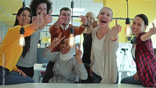 Multicultural happy business team making obscene gesture showing the middle finger photo