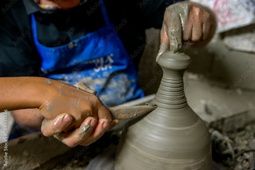 Pottery workshop in Tricase, Puglia, Italy. Adult showing a child the pottery technique.