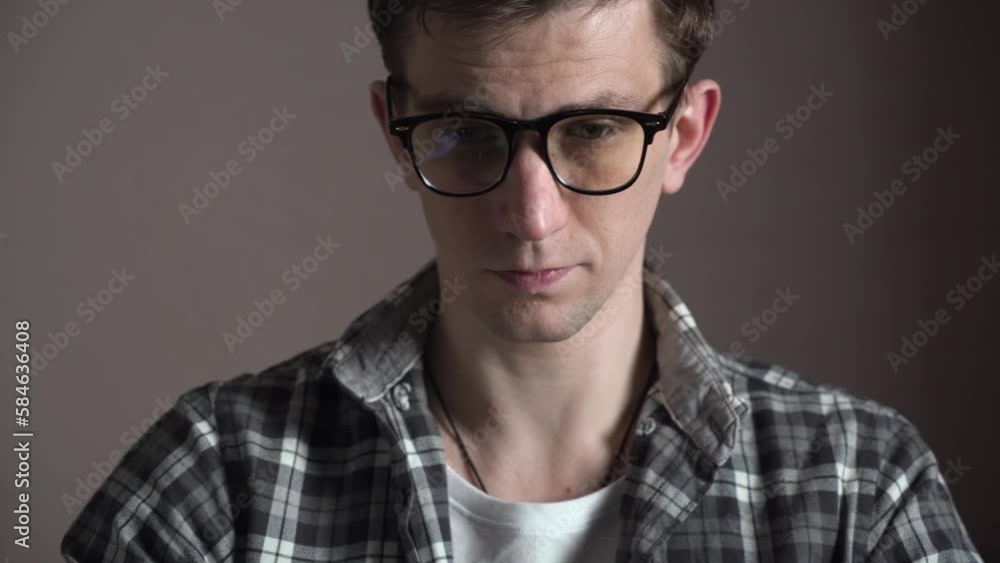 Young tired man closes his laptop after a bad day at work. He takes off his glasses and rubs his eyes from fatigue Young tired man closes his laptop after a bad day at work. He takes off his glasses and rubs his eyes from fatigue