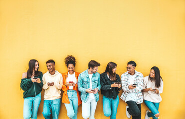 Group of young people using smart mobile phone device outside - Teenagers addicted to social media - College students watching smartphone in university campus - Modern technology concept
