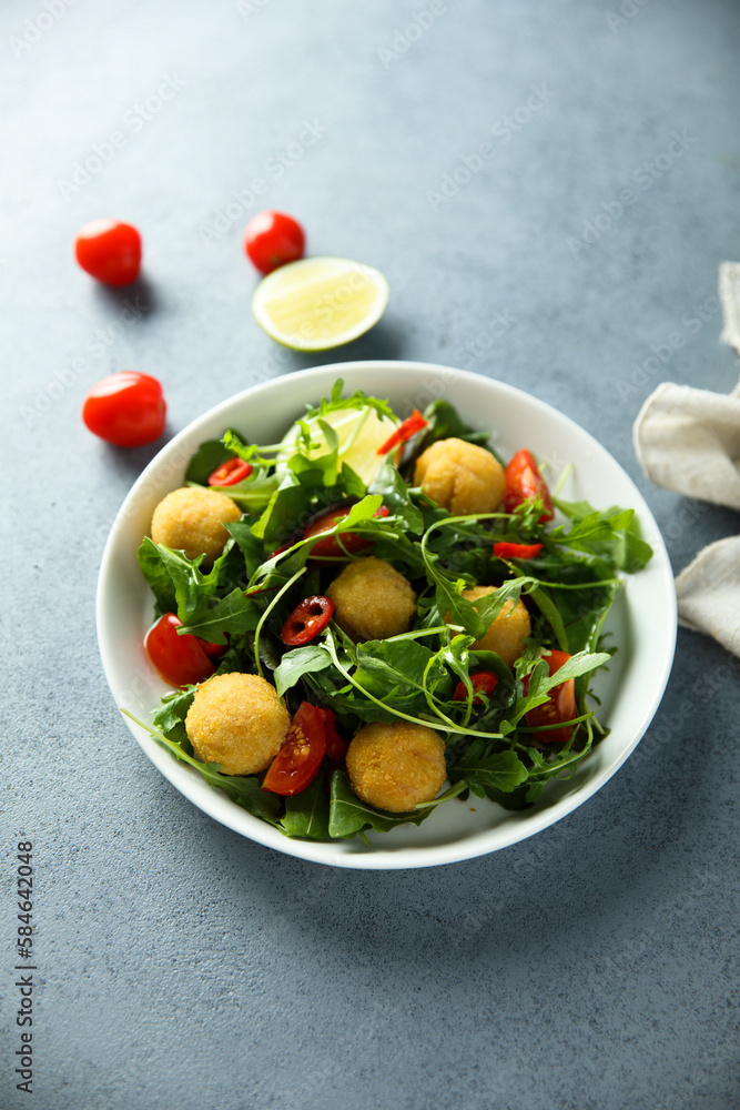 Healthy arugula salad with fish croquettes