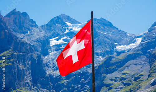 Red swiss flag in mountain in the background