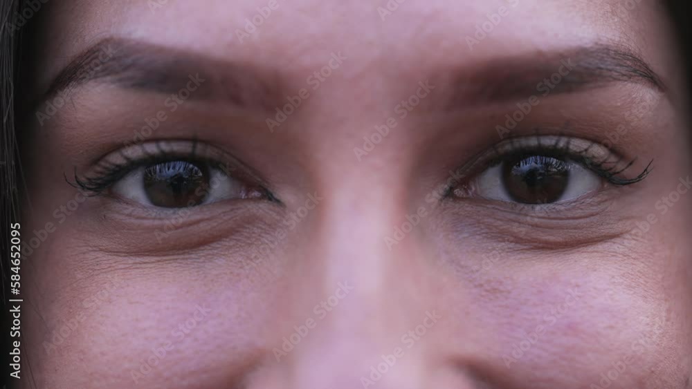 One Middle Eastern female woman eyes smiling at camera. Macro detail closeup of adult girl in her 20s One Middle Eastern female woman eyes smiling at camera. Macro detail closeup of adult girl in her 20s