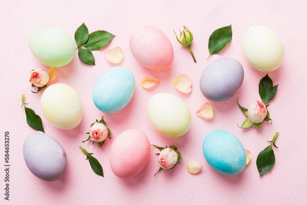 Happy Easter. Easter eggs on colored table with yellow roses. Natural dyed colorful eggs background top view with copy space Happy Easter. Easter eggs on colored table with yellow roses. Natural dyed colorful eggs background top view with copy space