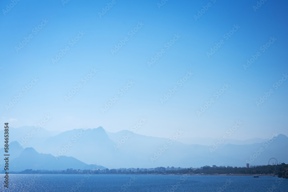 Calm sea against backdrop foggy mountains and blue sky, travel concept of beautiful places in turkey