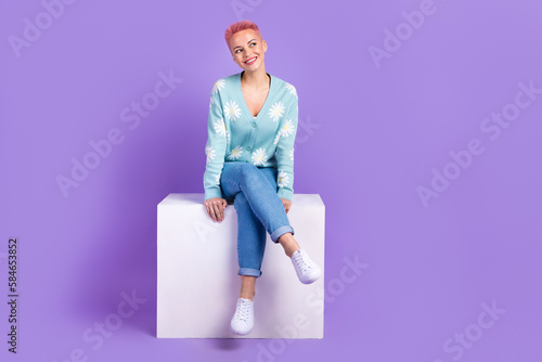Full body photo of cute woman pink dyed hair hipster wear blue stylish jumper jeans sit box look dreamy mockup isolated on violet color background