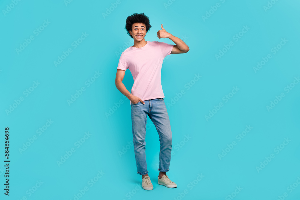 Full body size photo of young positive guy wear casual stylish outfit thumb up recommend his clothes brand isolated on aquamarine color background Full body size photo of young positive guy wear casual stylish outfit thumb up recommend his clothes brand isolated on aquamarine color background