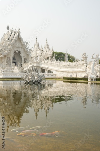 "Wat Rong Khun" Famous temple in chiangrai Thailand. Beautiful white temple with green field for travel landmark