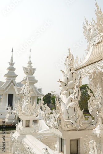 "Wat Rong Khun" Famous temple in chiangrai Thailand. Beautiful white temple with green field for travel landmark