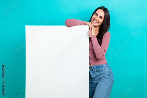 Portrait of lovely positive girl toothy smile demonstrate empty space ad blank isolated on turquoise color background