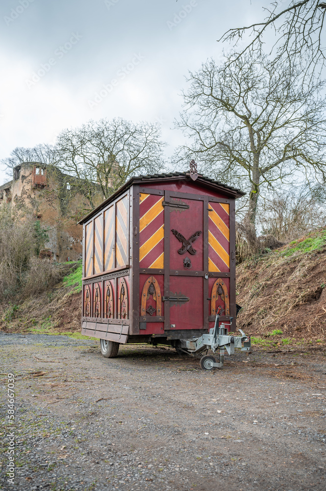 Decorative Trailer made of wood, Christmas market stand on a trailer in front of an old castle, Ronneburg Castle, Germany, vertical shot