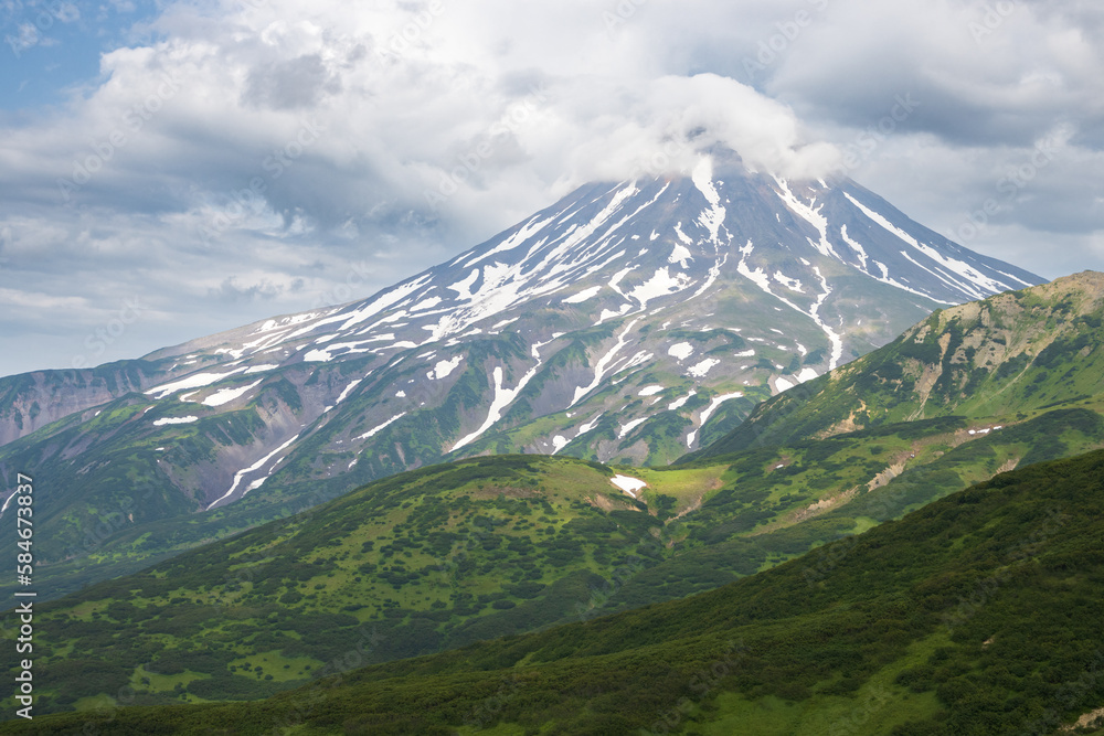 Fototapeta premium View of the volcano. Travel and tourism on the Kamchatka Peninsula. Beautiful nature of Siberia and the Russian Far East. Vilyuchinsky Volcano (Vilyuchinskaya Sopka), Kamchatka Territory, Russia.