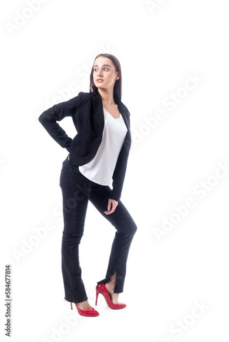 A girl in a black pantsuit and in a white top posing on a white background.