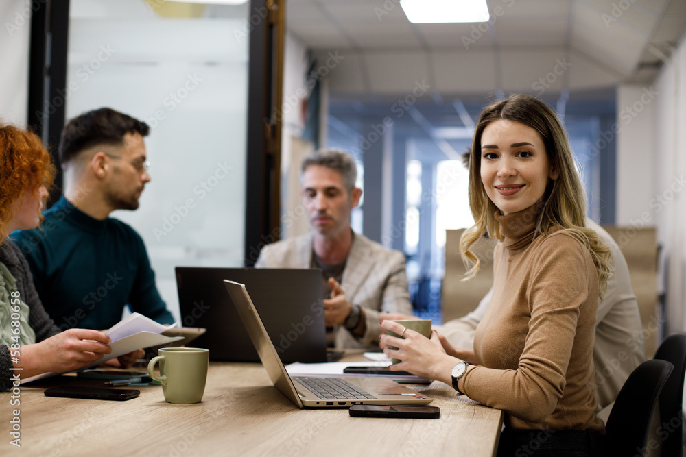 Mixed group of business people sitting around a table and talking
Mixed group of business people sitting around a table and talking
