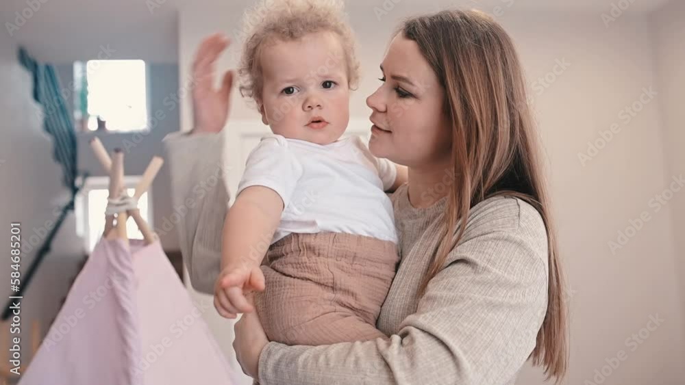 mother holds a curly-haired baby in her arms. Hugs and kisses him. Slow motion mother holds a curly-haired baby in her arms. Hugs and kisses him. Slow motion
