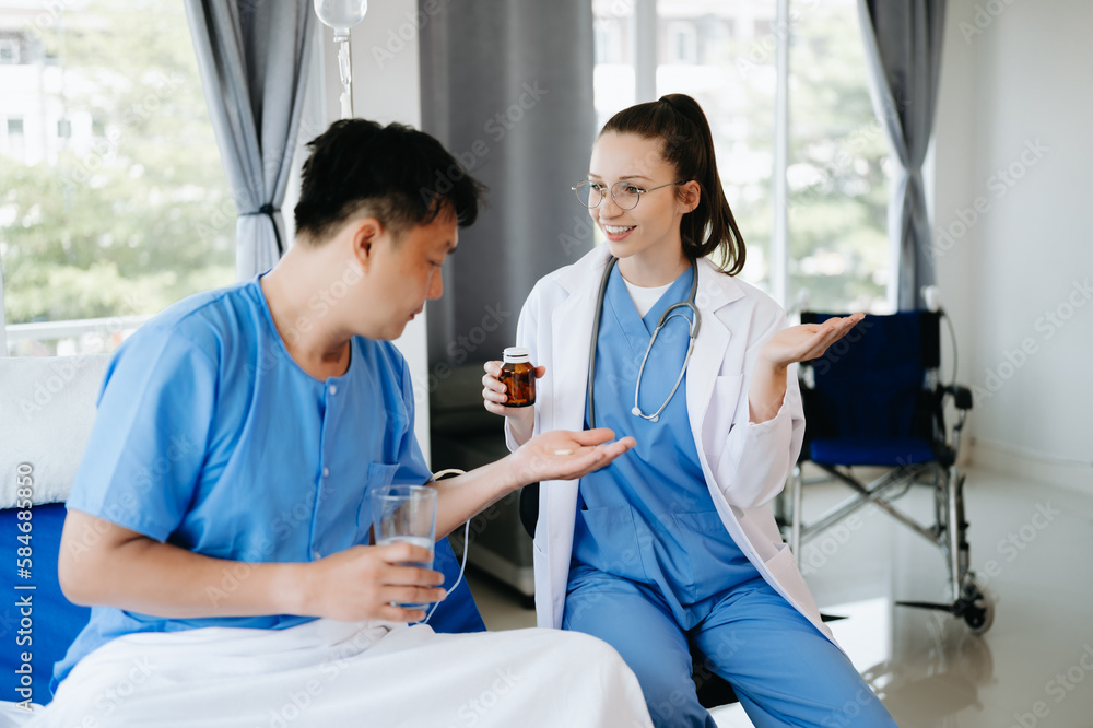 Doctor in white suit take notes while discussing and Asian elderly, man patient who lying on bed with receiving saline solution in hospital or clinic. Doctor in white suit take notes while discussing and Asian elderly, man patient who lying on bed with receiving saline solution in hospital or clinic.