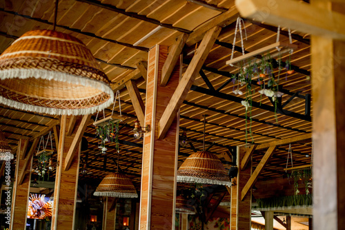 Wicker straw lamps, wooden roof. Trendy interior design of a hipster cafe in loft style