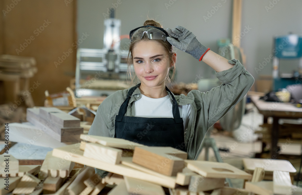 Young female carpenter working Project in her workshop. Female carpenter making wooden furniture. Young female carpenter working Project in her workshop. Female carpenter making wooden furniture.