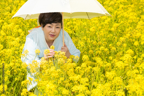 Japanese woman in a beautiful yellow flowers field