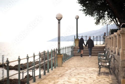 Young couple walking in the park of Lungomare promenade coastline of famous Adriatic sea resort Opatija Croatia Istria photo