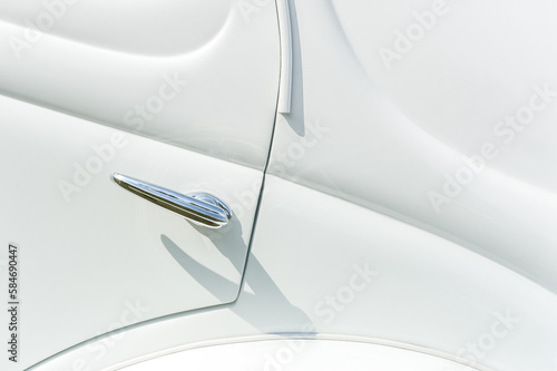 chromed door lever on a white retro vehicle panel