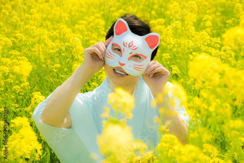 Japanese woman in a beautiful yellow flowers field