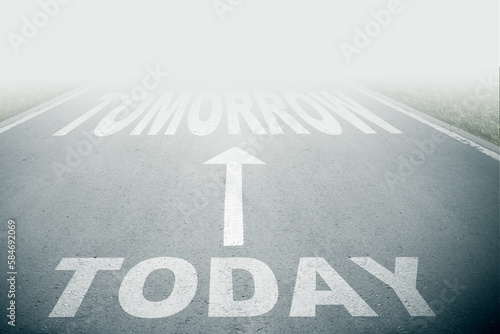 Today next to tomorrow text on asphalt road with white arrow sign on road goes into fog. Direction way sign. Moving forward concept. Unclear ahead or negative tomorrow concept.