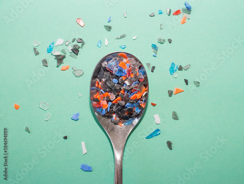 Spoon is full of small and colorful pieces of plastic .  Plastic products and their parts overwhelm the entire planet.
