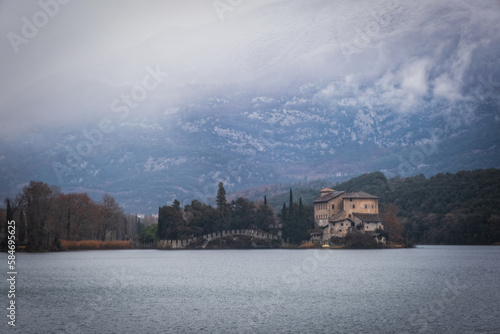 Beautiful view of the castle on the shores of Lake Toblino, Trentino, Italy. Cloudy day in January 2023