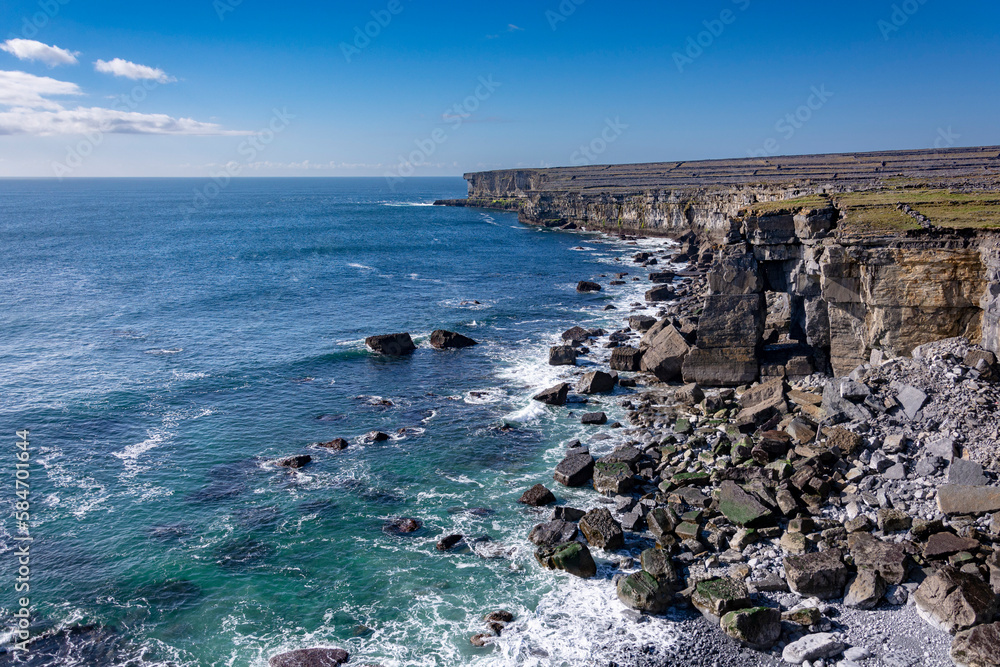 White waves on a blue Irish rocky cliff in a blue sky dasy