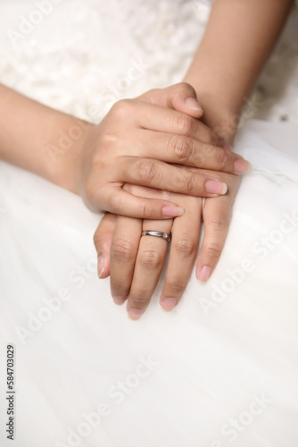 Closeup of young women's hands, the bride in a wedding dress is sitting