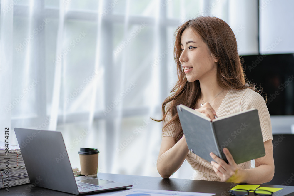 Asian female financial analyst or accountant using laptop in accounting firm working on financial auditing and budgeting using calculator and laptop Asian female financial analyst or accountant using laptop in accounting firm working on financial auditing and budgeting using calculator and laptop