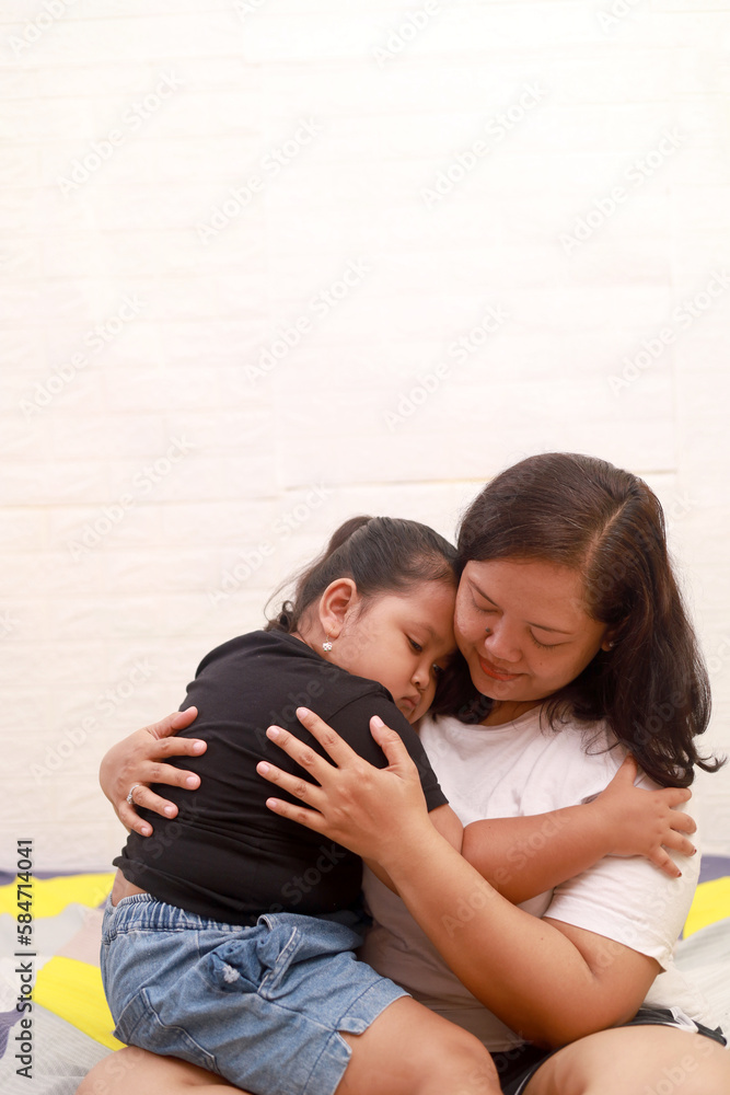 Sad asian girl hugging his mother on the bed at home Sad asian girl hugging his mother on the bed at home