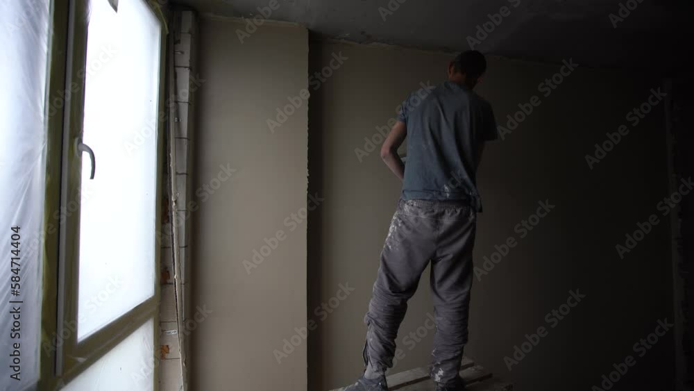 man plasterer construction worker at work with trowel, plastering a wall. man plasterer construction worker at work with trowel, plastering a wall.