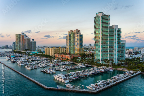 Marina in Miami Beach with the Miami skyline in the background at sunset with many boats © crazymonkstudio