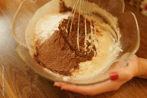 Close-up shot of mixing ingredients for making cakes, cookies or pastries. Detail images of beating butter, flour and eggs for dough making.