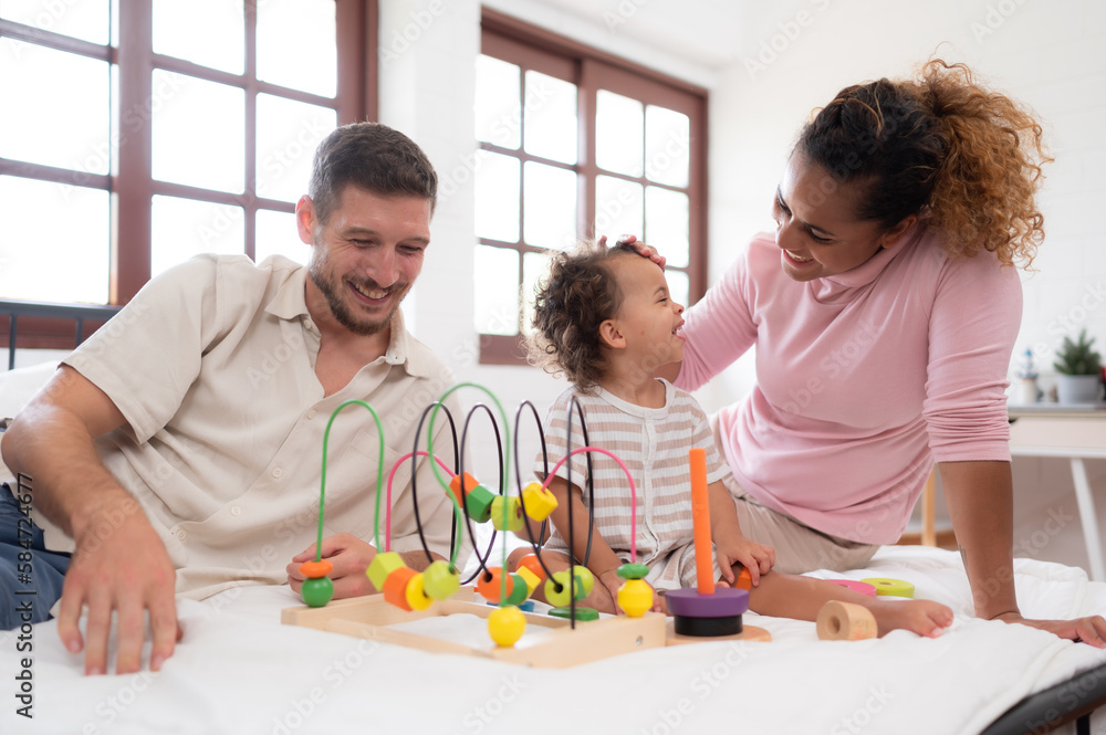 Parents with little girl have fun playing with your new toys in the bedroom together. Toys that enhance children's thinking skills. Parents with little girl have fun playing with your new toys in the bedroom together. Toys that enhance children's thinking skills.