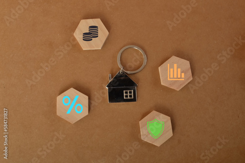 House keychain with graph, insurance, percentage and money symbols.