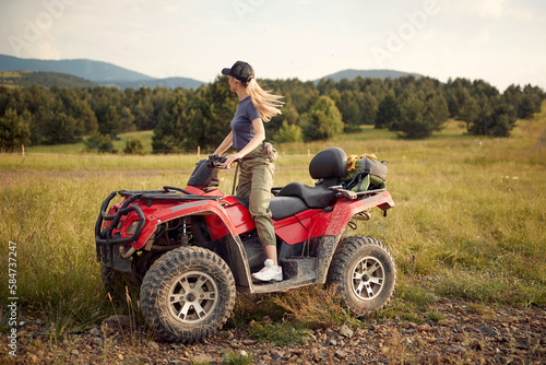 A young girl is enjoying the scenery while riding a quad in the nature. Riding, nature, activity