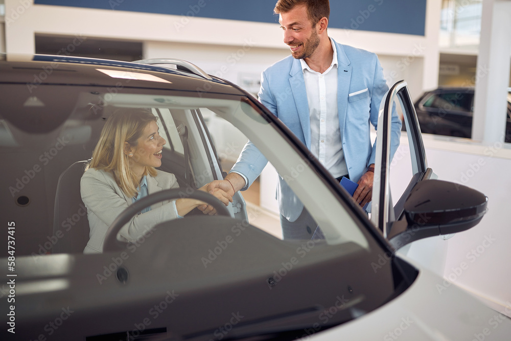 Obraz premium Manager shaking hand with buyer in new car
