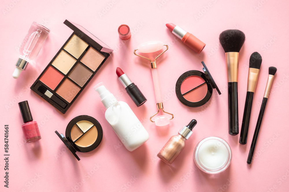Makeup cosmetic products on pink background. Cream, lipstick, shadow and brushes. Flat lay image with copy space. Makeup cosmetic products on pink background. Cream, lipstick, shadow and brushes. Flat lay image with copy space.