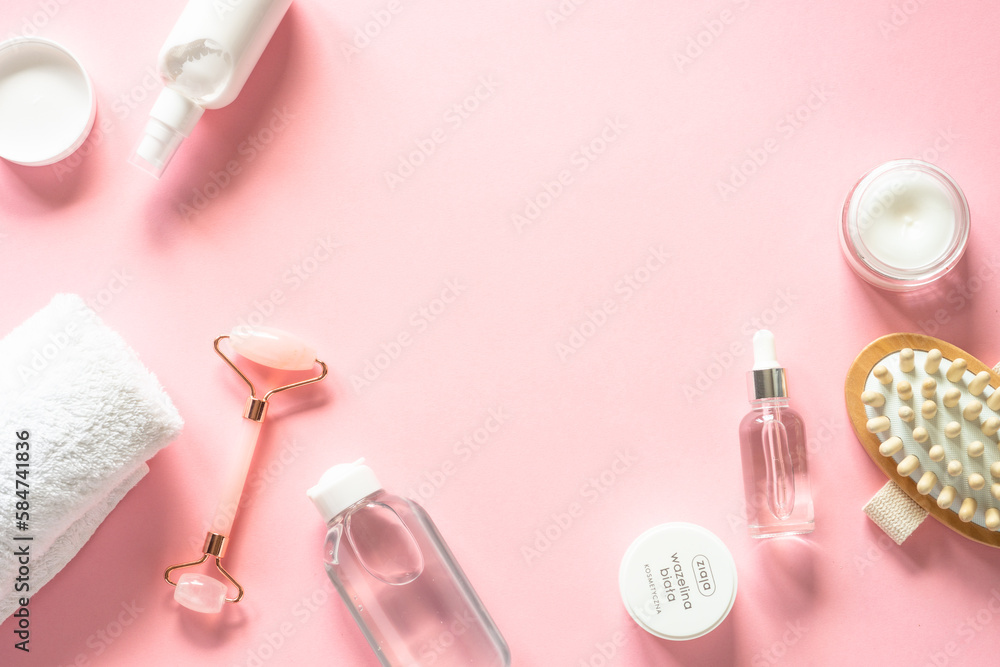 Skin care product, cream, soap serum, jade roller. Natural cosmetics on pink. Flat lay image with copy space. Skin care product, cream, soap serum, jade roller. Natural cosmetics on pink. Flat lay image with copy space.