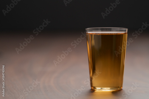 Organic apple cider in tumbler glass on wood table