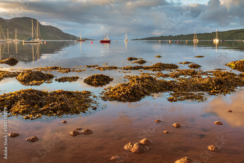 Boats moored in the sheltered bay of Lamlash, with the shores of Holy Island beyond, on the Isle of Arran in Scotland. photo