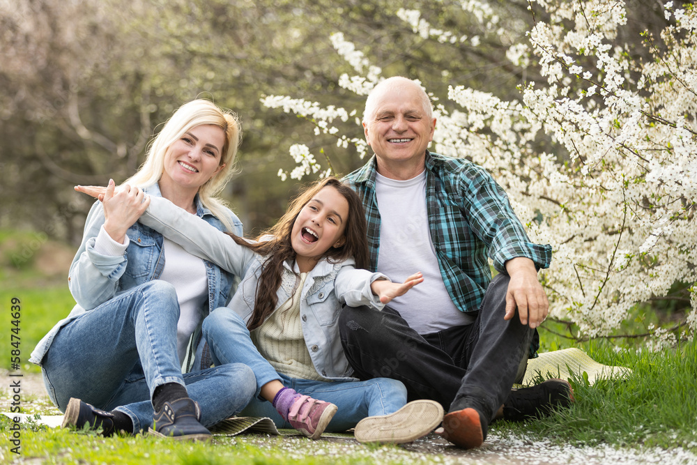 family having picnic in park, garden with flowering trees, spring family having picnic in park, garden with flowering trees, spring