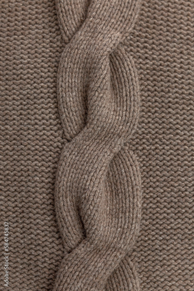Braid pattern on knitted fabric. Hobby and needlework. Close-up. Vertical. Braid pattern on knitted fabric. Hobby and needlework. Close-up. Vertical.
