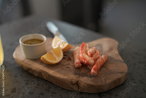 Crab legs with lemon and dressing on olive woob board photo