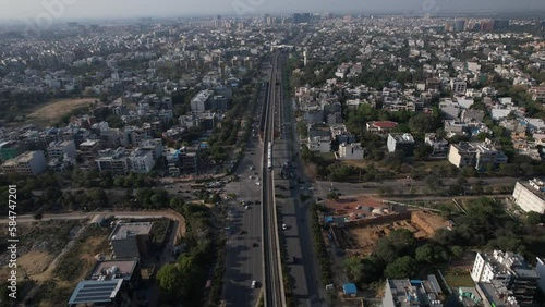 Aerial Drone footabe of Gurgaon Rapid Metro train skyscrapers skyline cyberhub delhi ncr India golf course road traffic vehicles transportation buildings infrastructure  photo